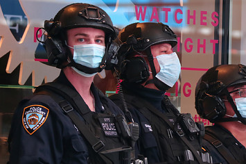 NYPD police officers wear masks as they stand guard in Times Square
