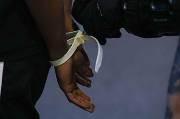 A close up view of a protestor's hands in plastic handcuffs after being arrested