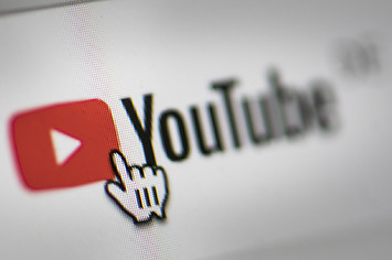 In this photo illustration the mouse cursor is pictured on the YouTube logo.