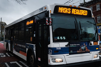A bus displays a message noting masks are required to board