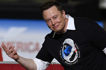 Elon Musk gestures to audience after being recognized by Donald Trump.