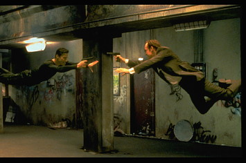 Keanu Reeves and Hugo Weaving face each other in a scene