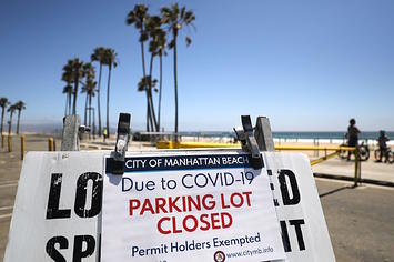A sign announces that a beach parking lot is closed on Independence Day
