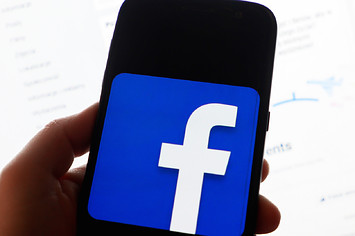 Facebook logo is displayed on a mobile phone screen