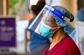A medical worker wears a protective face mask