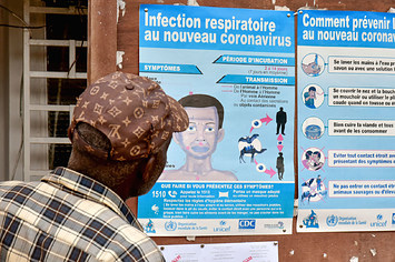 A man watches posters about COVID 19 in Yaounde, Cameroon