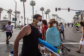 People cross the street amid coronavirus pandemic in Huntington Beach, California