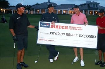Peyton Manning, Tom Brady, Tiger Woods and Phil Mickelson pose with a big check.