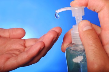 Man squeezes hand sanitizer bottle.