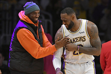 LeBron James has a moment on the sideline with former Laker Kobe Bryant.