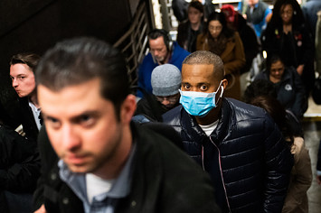 A man wearing a protective mask is seen on a subway platform in New York City.
