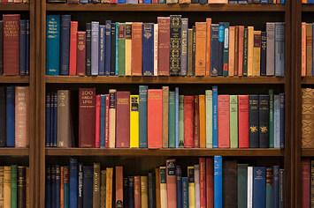A selection of multi coloured books on a library bookshelf in Cardiff, United Kingdom.