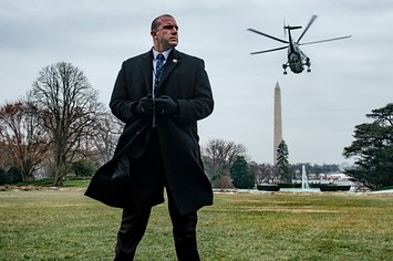 A Secret Service agent stands watch as President Trump departs on Marine One