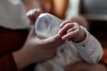 A baby drinks milk from a bottle.