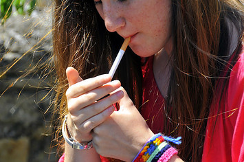 Teenager lighting up a cigarette.