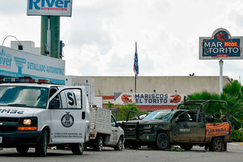 A forensic service van is seen next to a vehicle with bullet holes