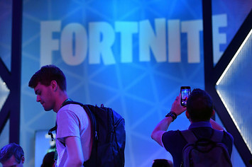 A visitor takes pictures at the stand of the "Fortnite" computer game