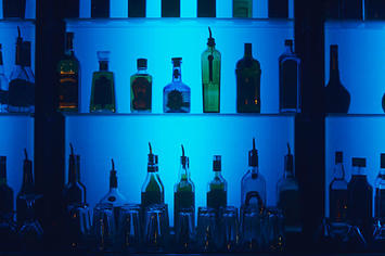 A stock photo of alcohol bottles at a bar.