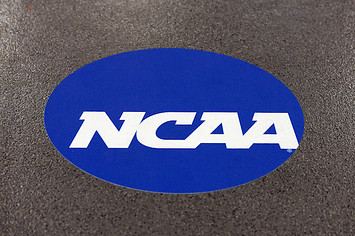 NCAA logo is displayed on the floor during the NCAA Men's Gymnastics Championship.