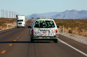A car drives with 'Area 51' written on the back