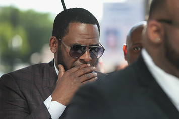 R&B singer R. Kelly covers his mouth as he speaks