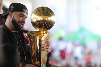 Drake holds the Larry O'Brien NBA Championship Trophy