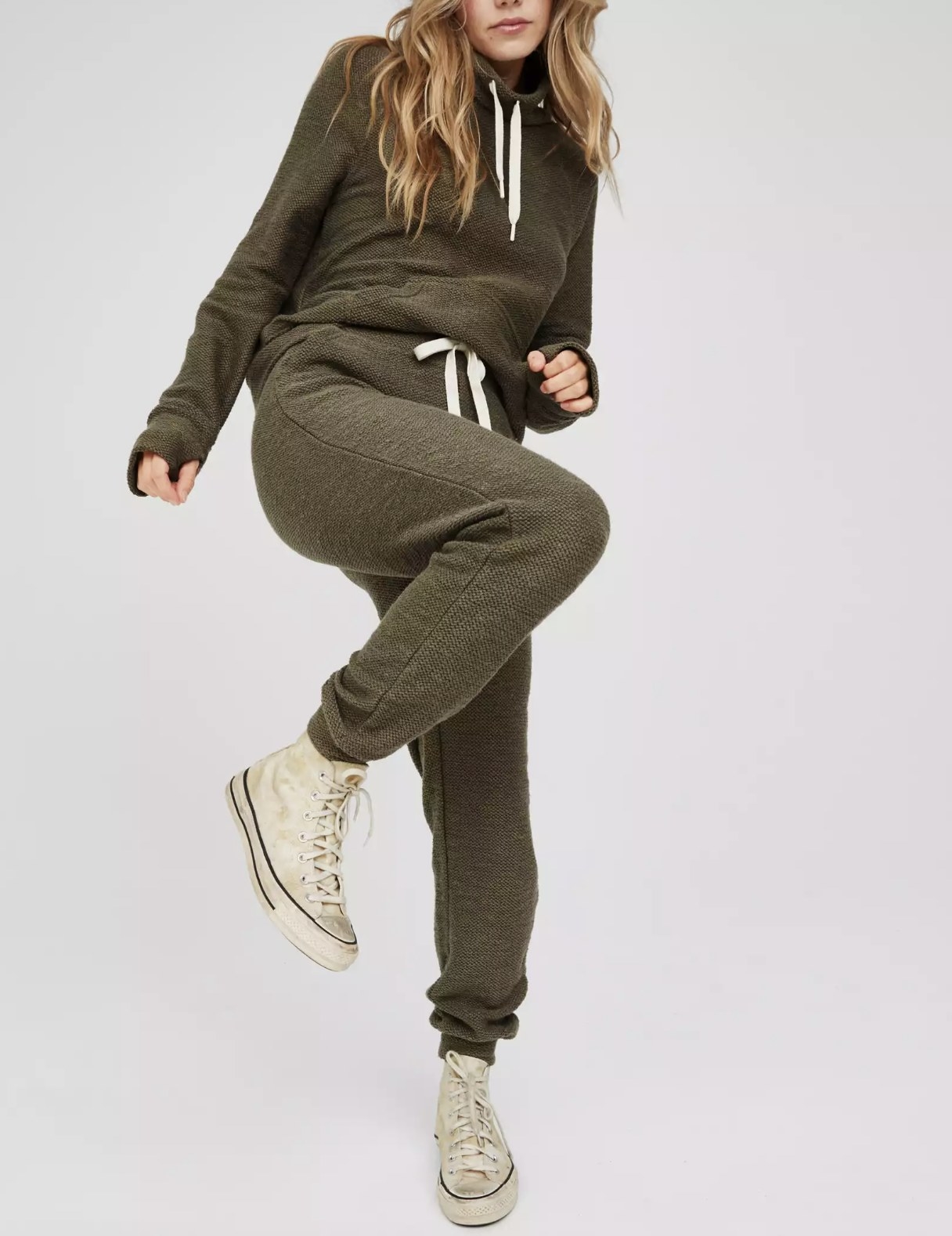 model raising knee in the green joggers