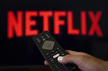 A person holds a Netflix remote control.