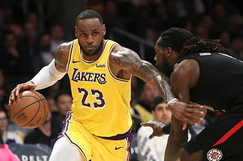 LeBron James #23 of the Los Angeles Lakers dribbles past Montrezl Harrell