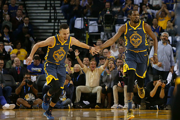 Stephen Curry #30 and Kevin Durant #35 of the Golden State Warriors celebrate a basket