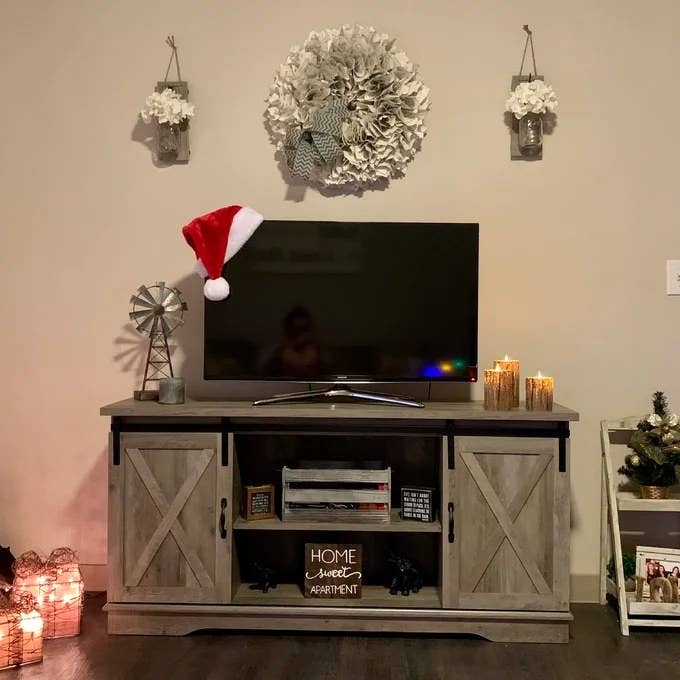 The wood TV stand with sliding farmhouse doors and two open shelves