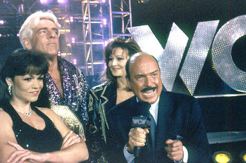 Woman, Ric Flair, Miss Elizabeth and Gene Okerlund circa 1998 during a WCW broadcast.
