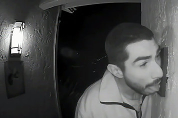 This is a photo of man licking doorbell.