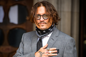 Johnny Depp acknowledges photographers outside Royal Courts of Justice.