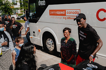 Pascal Siakam and Marci Ien handing out laptops to kids in Regent Park