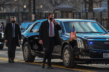 Secret Service members walk along side the Presidential Motorcade