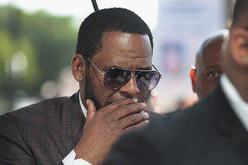 R. Kelly covers his mouth as he speaks to members of his entourage as he arrives at the Leighton Criminal Courts Building