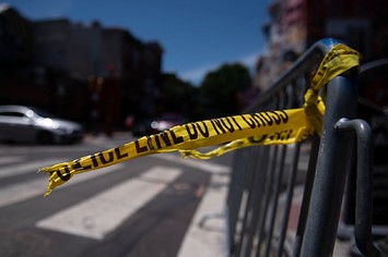 Police tape hangs from a barricade at the corner of South and 3rd Streets in Philadelphia