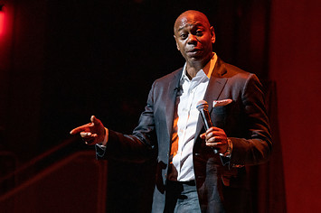 Dave Chappelle seen speaking to audience onstage.