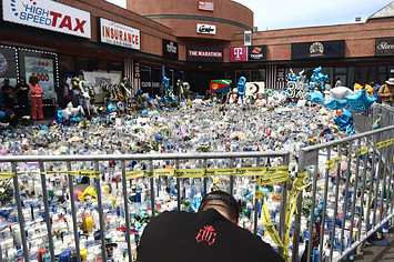 A man kneels at a memorial set up outside The Marathon Clothing store before the funeral procession for slain hip hop artist Nipsey Hussle