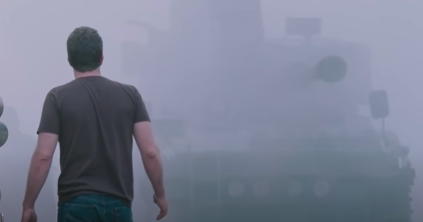 A man stands before thick fog