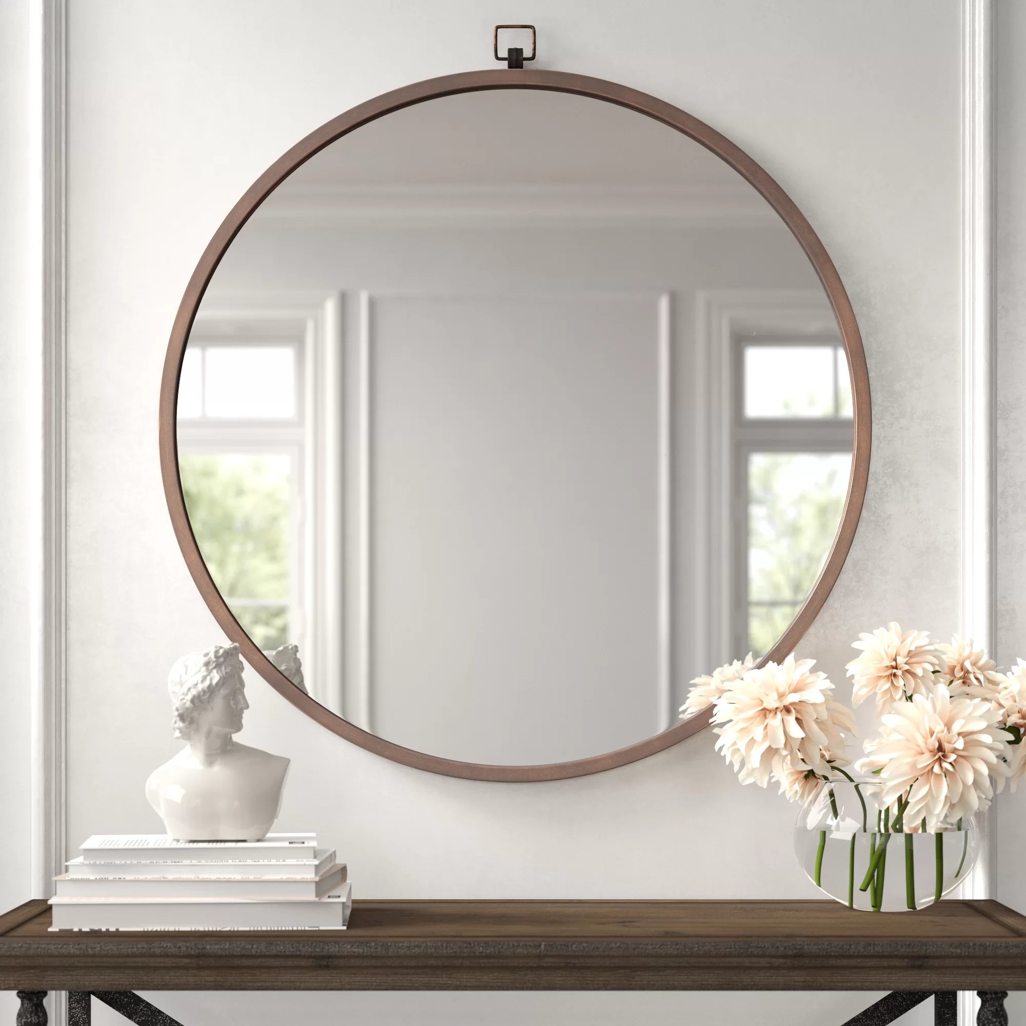 The circular mirror hanging in an entryway
