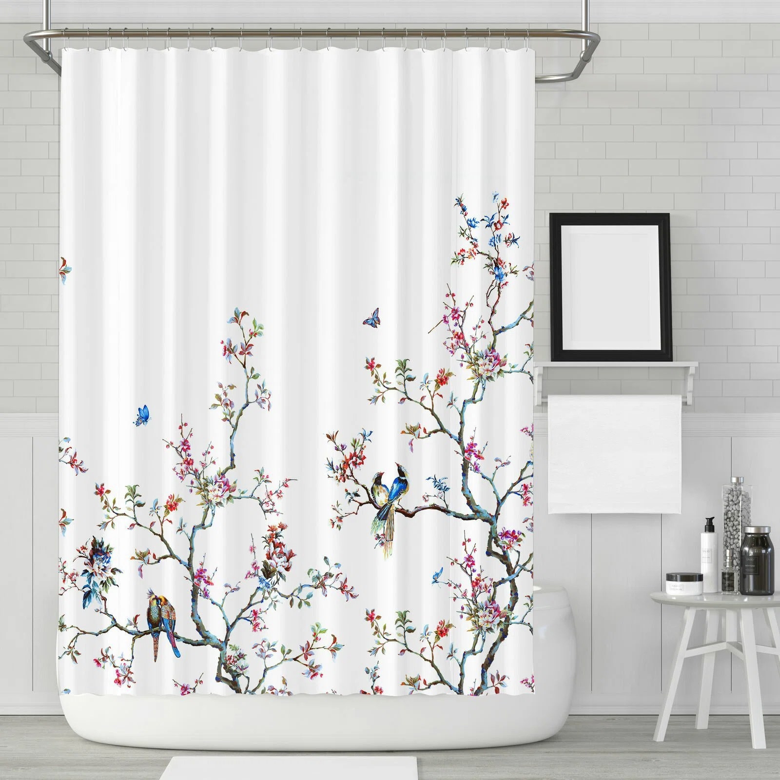The shower curtain with a colorful print that includes delicate flowers and birds