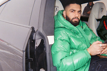 AR Paisley in a green puffer jacket sitting in a car. Behind him, someone is texting.