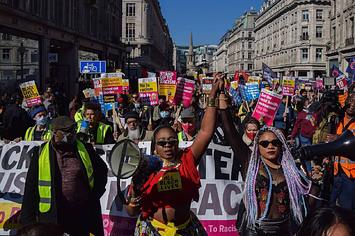 Protesters carrying megaphones hold each other's hands during the demonstration in Regent Street