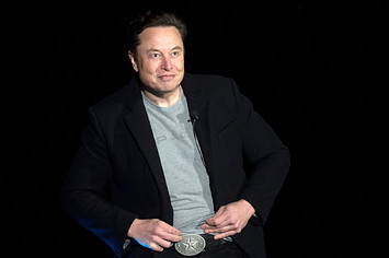 Elon Musk is pictured standing in front of other people