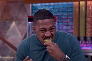 Nick Cannon eats a "Snickle," a Snickers bar sandwiched between a split pickle, on his talk show.