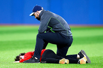 A kid being tackled after running onto the field at a Toronto Blue Jays game