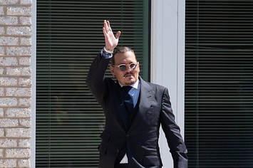 Johnny Depp gestures to fans during a break outside court