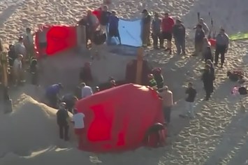 View of a beach as rescue workers respond to a sand collapse
